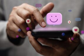 image showing a finger clicking a mobile phone and a smiley face