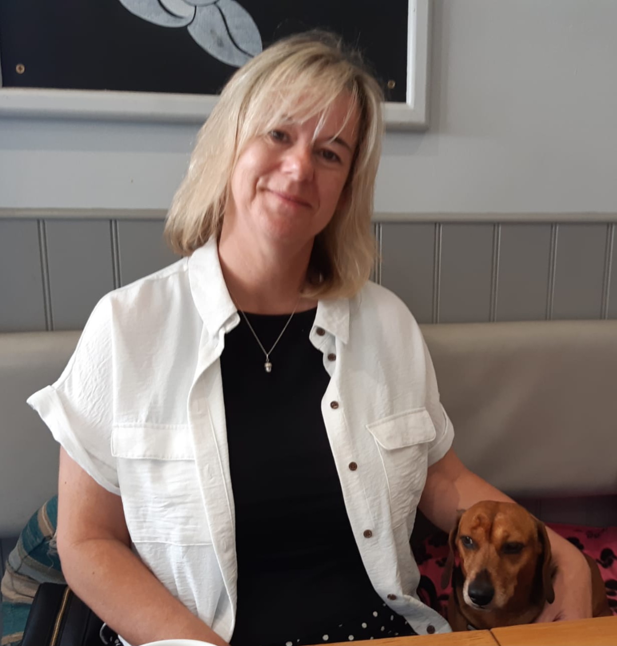 A woman sitting down with her dog.